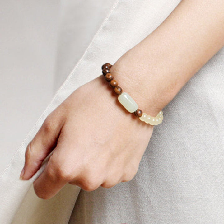 Armband Sandelholz Jade am Handgelenk, braune Perlen mit hellem Stein