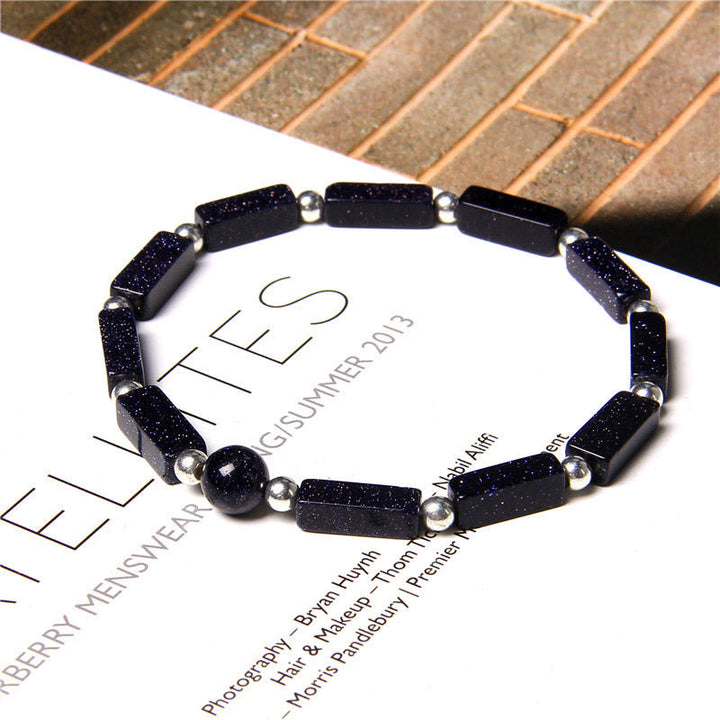 Schwarzes Armband mit Steinen auf weißem Papier, Tigerauge Amethyst Design