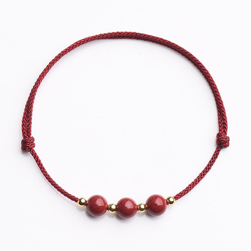 Armband Zinnober – Glück & Segen rote Perlen Goldakzente elastisch Flachaufnahme