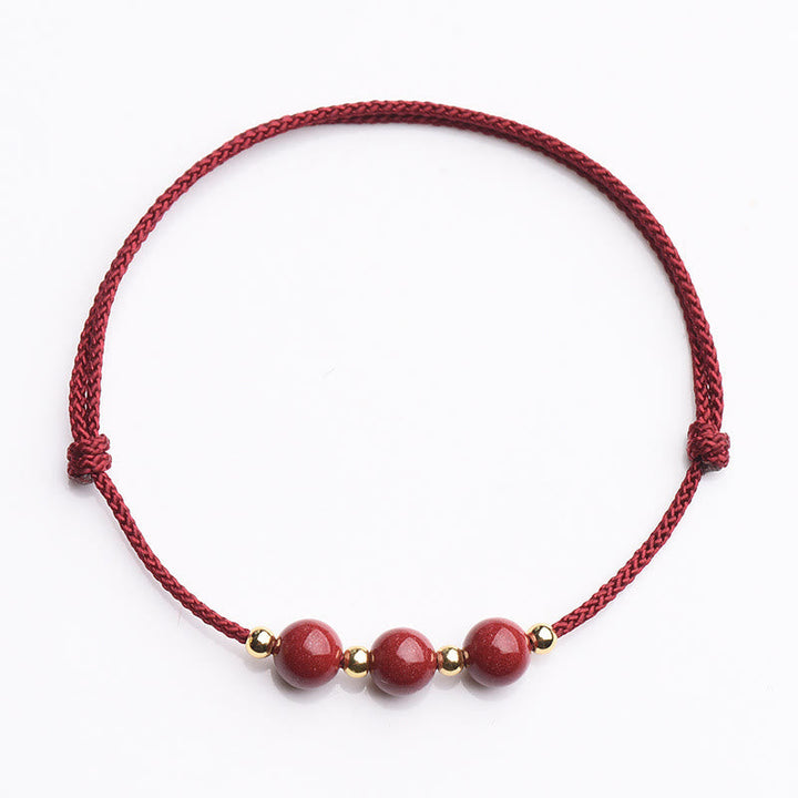 Armband Zinnober – Glück & Segen rote Perlen Goldakzente elastisch Flachaufnahme
