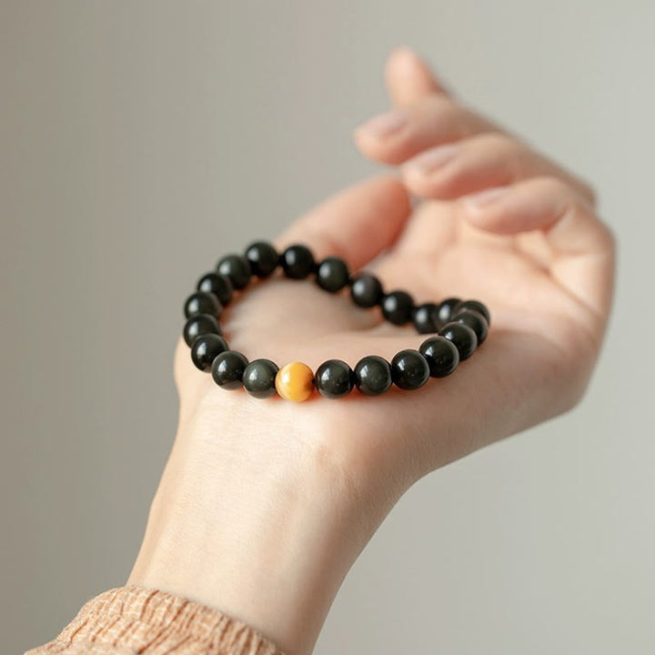 Armband Tigerauge Obsidian mit schwarzen Perlen am Handgelenk getragen