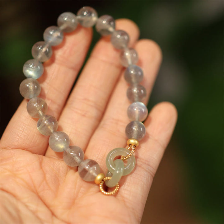 Mondstein Jade Armband am Handgelenk mit goldenen Perlen elegant getragen