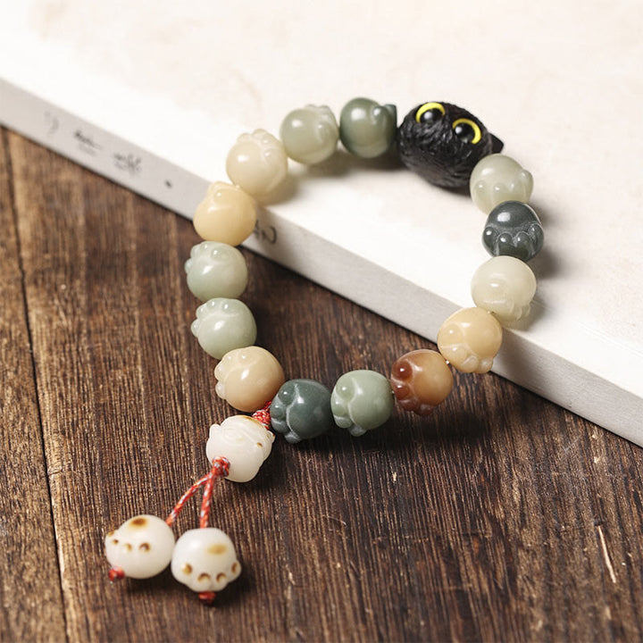 Armband Bodhi Ebenholz Katze mit Perlen auf Holzoberfläche.