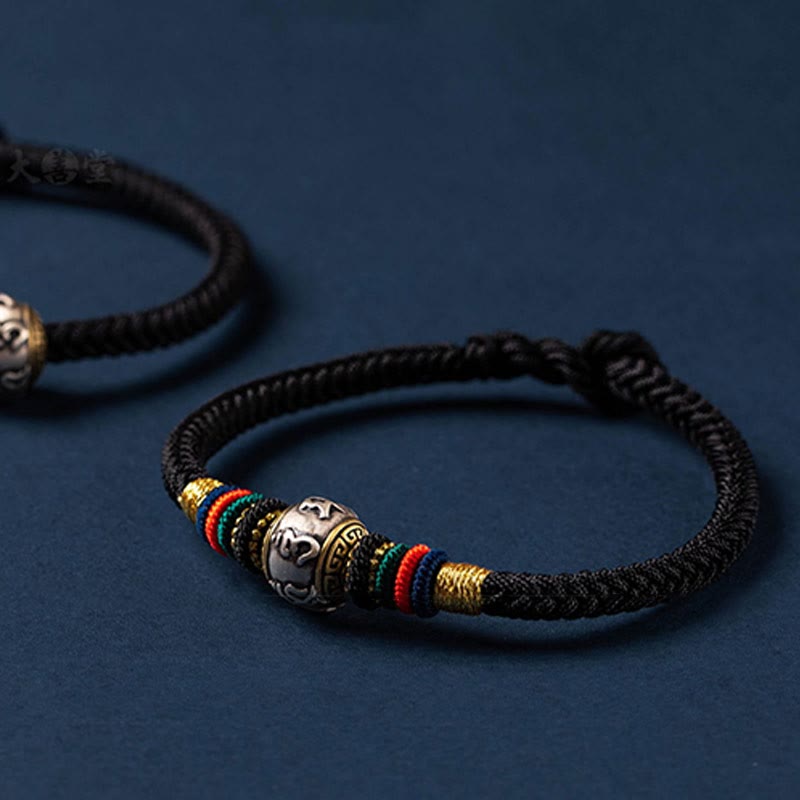 Schwarzes Seiden-Armband mit silbernem Om Mani Padme Hum Anhänger elegant.