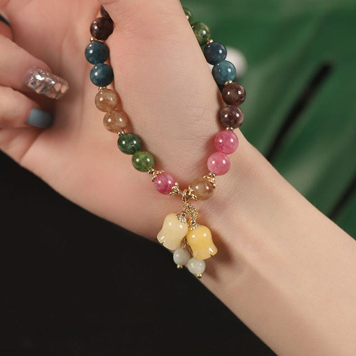 Buntes Turmalin Armband mit Blumen-Anhänger an weiblichem Handgelenk getragen