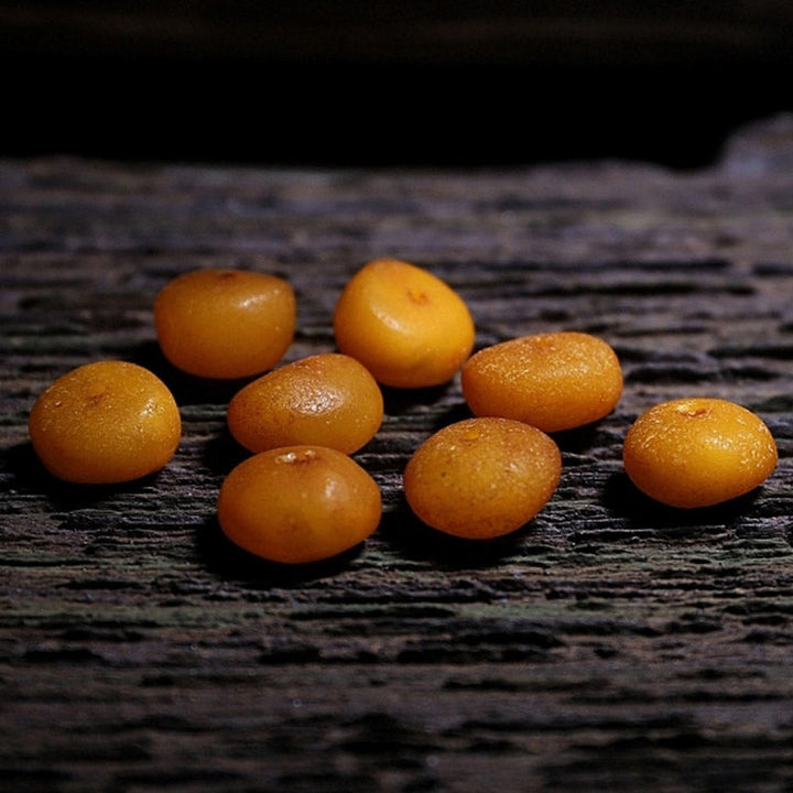 Mala Bernstein – Glück orange Perlen Holzoberfläche Naturstein glänzend