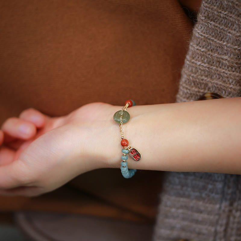 Armband Roter Achat Jade am Handgelenk mit türkisen Perlen getragen