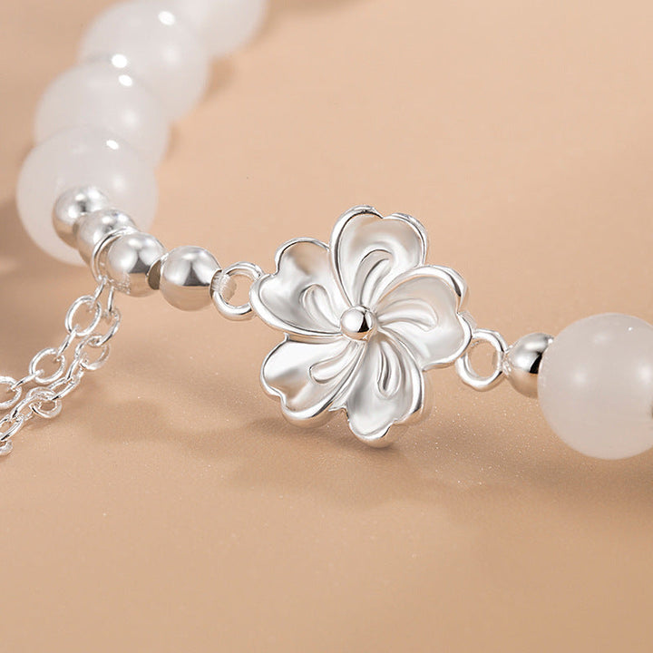 Armband Weiße Jade Pfirsichblüte Glück silberne Blütenperlen elegant getragen