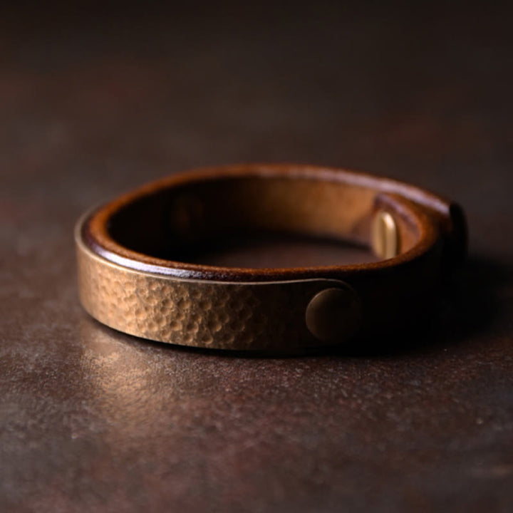 Gehämmertes Kupfer Armband mit Druckknopf auf dunklem Hintergrund glänzend