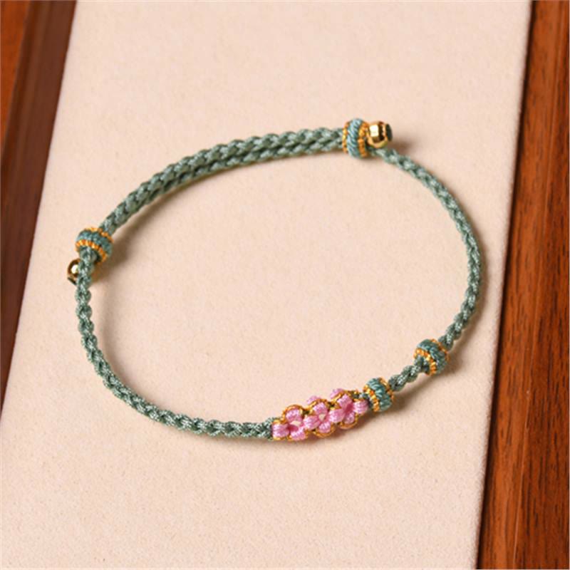 Armband Pfirsichblüte – Schutz grünes Seil rosa Blüten goldene Perlen