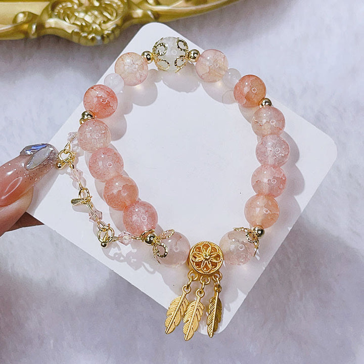 Rosaquarz Armband mit Traumfänger-Anhänger goldfarben elegant.