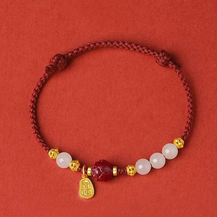 Armband Weiße Jade Zinnober Lotus Glück golden verziert rot Hintergrund