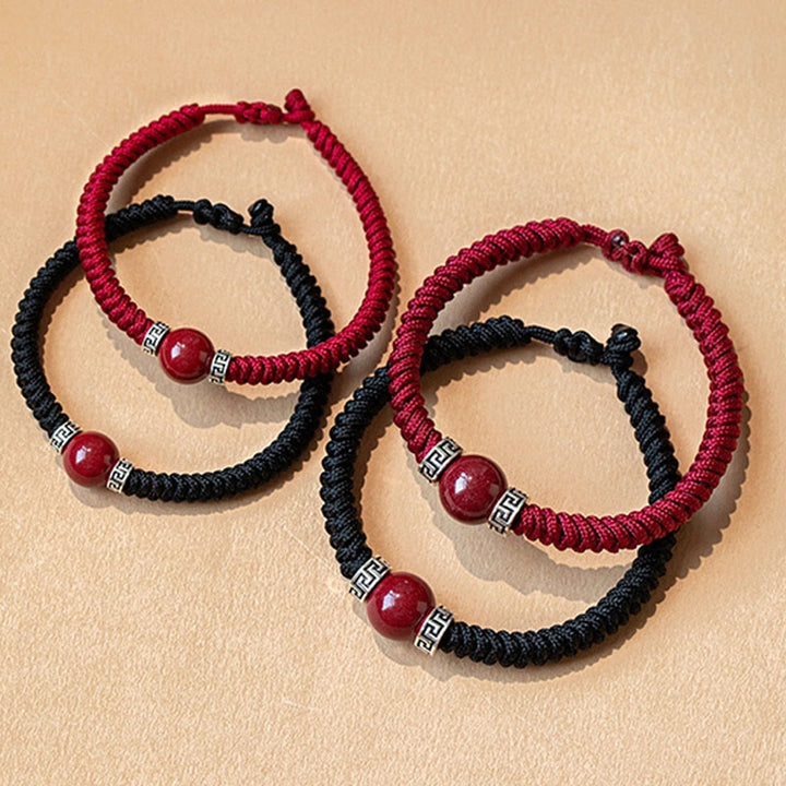 Rote und schwarze Armbänder mit silbernen Perlen elegant arrangiert.