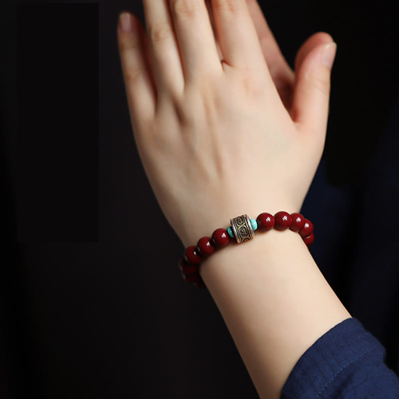 Rotes Armband mit Silber-Zinnober Perlen am Handgelenk getragen elegant.
