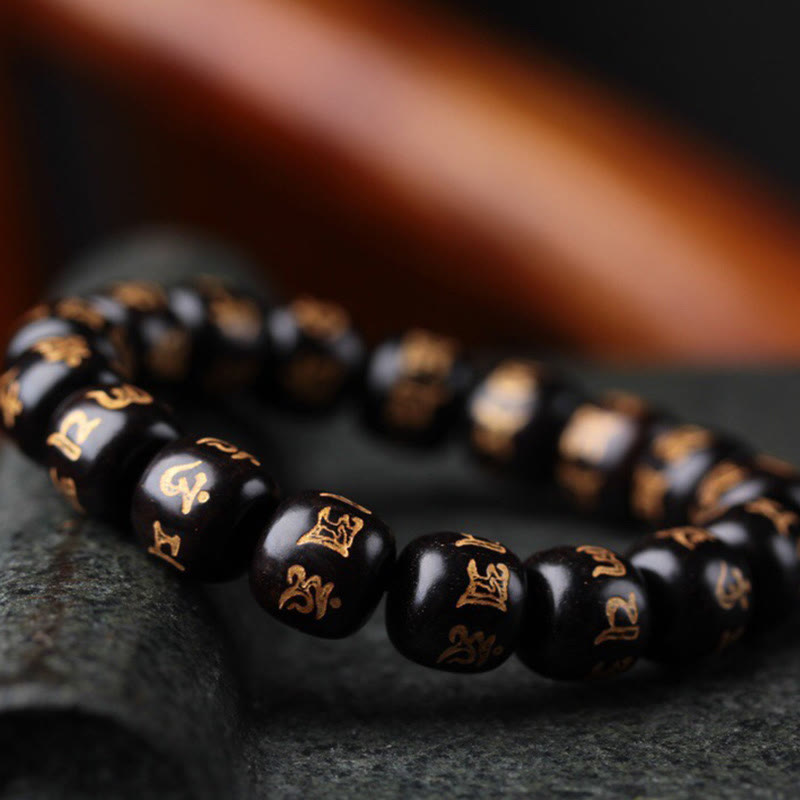 Schwarzes Ebenholz Armband mit Om Mani Padme Hum Symbolen elegant.