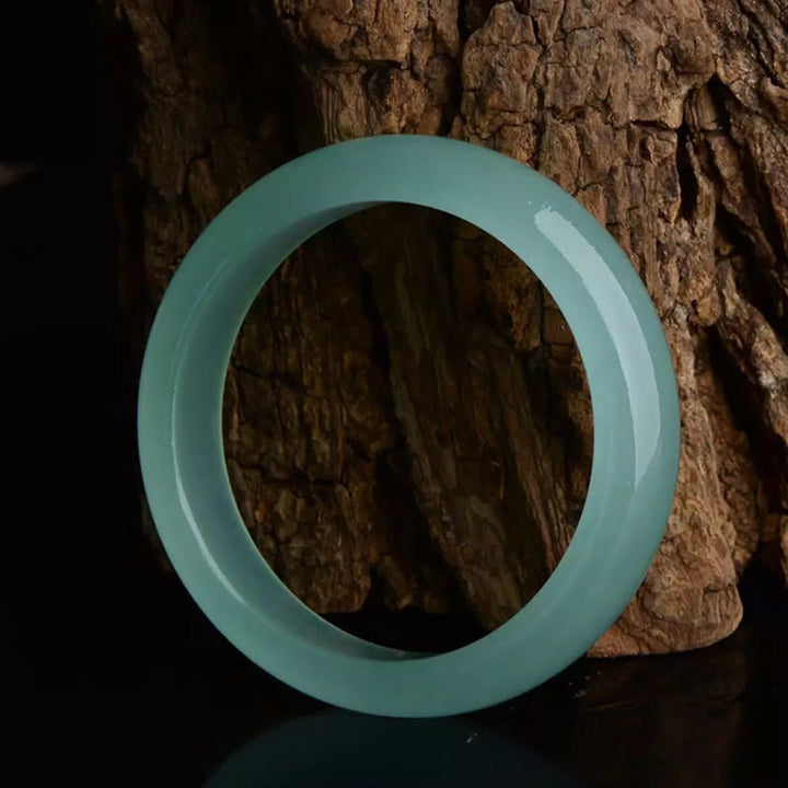 Türkises Jade Armband vor Baumrinde, glatter Stein Armband Jade – Glück & Heilung Segen