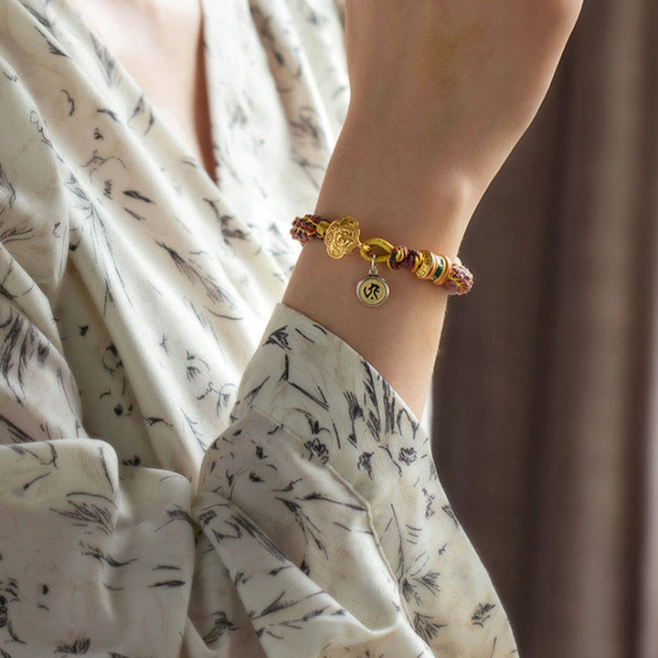 Goldenes Armband mit Om-Charm am Handgelenk elegant getragen