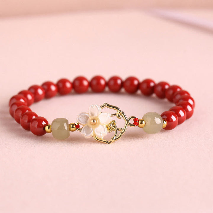 Armband Zinnober Jade – Segen mit goldenem Blütenanhänger elegant.