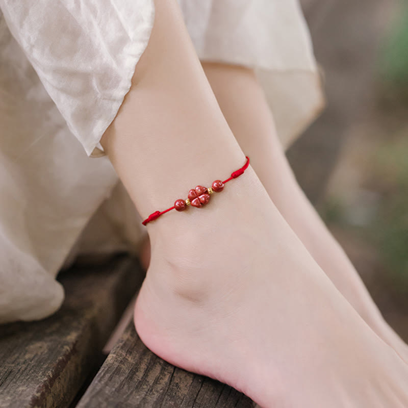 Rotes Armband Zinnober Kleeblatt am Fuß getragen, Liebe & Segen Schmuck