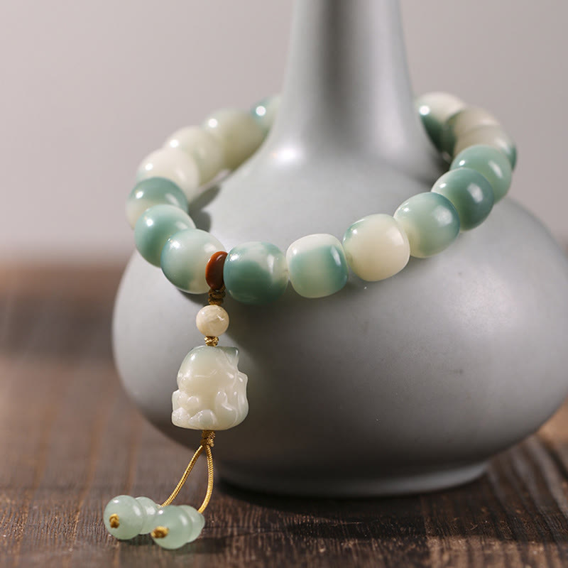 Jade Armband mit Bodhi-Perlen und Anhänger auf Keramikschale displayed.