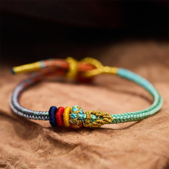 Armband Geflochten Friedensknoten – Schutz & Glück farbig auf Leinen Detailaufnahme