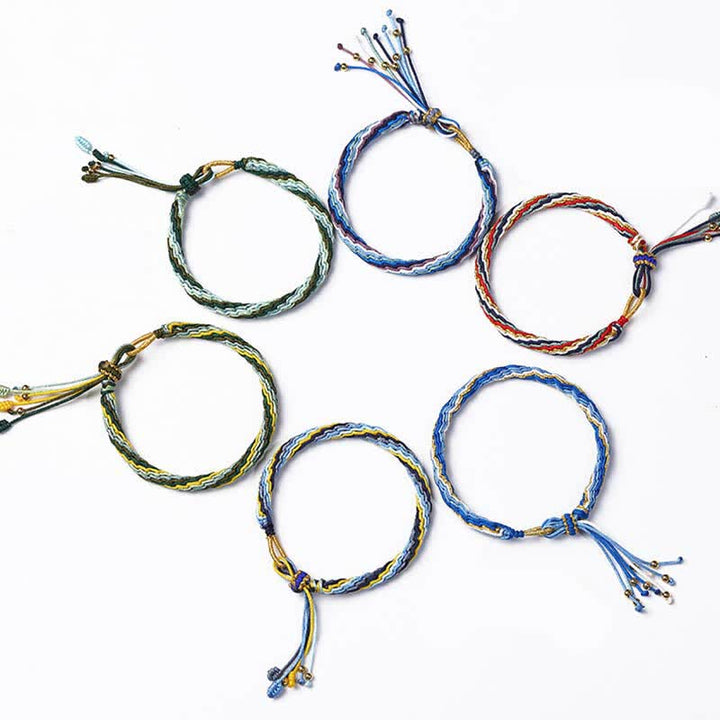 Sechs bunte Armbänder Flachlage geflochtene Schnüre Heilsteine Samsara Knot Design