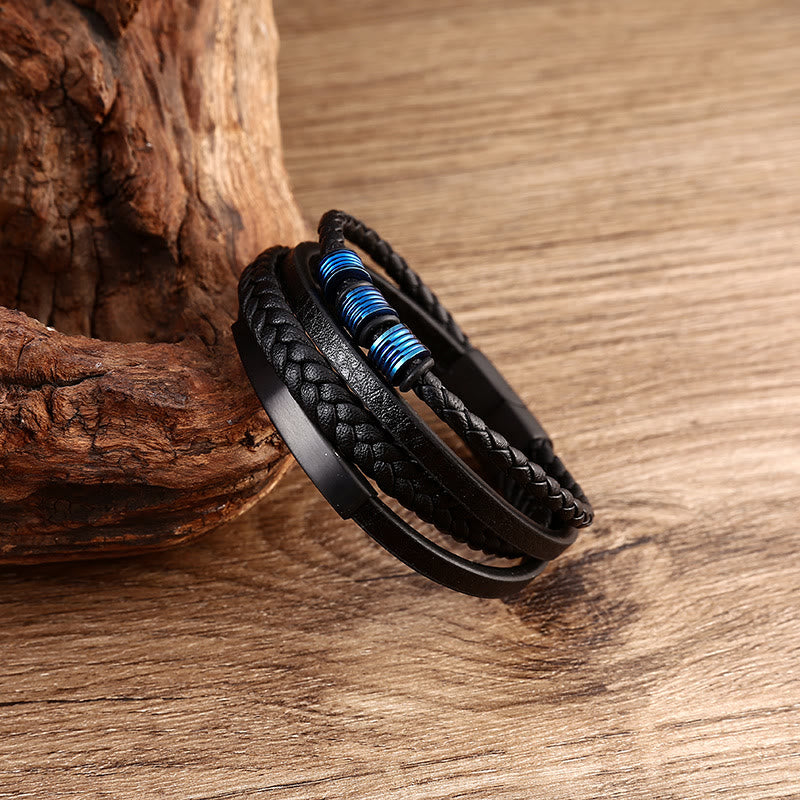 Schwarzes magnetisches Armband mit blauen Akzenten auf Holz.