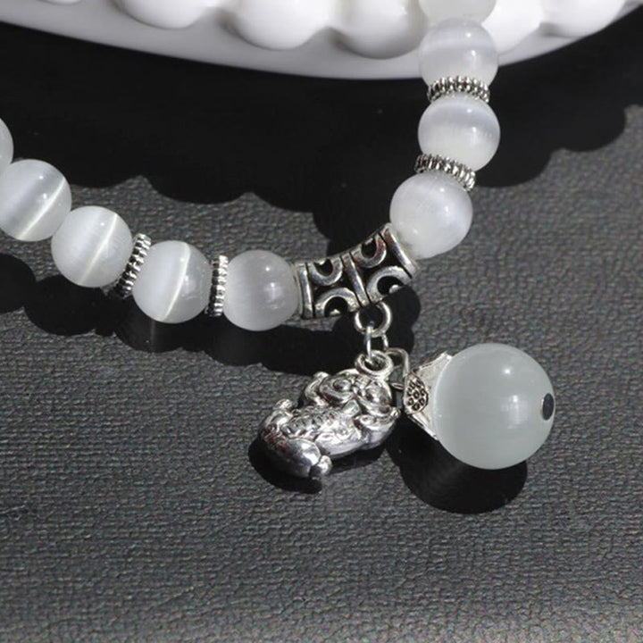 Weißes Katzenauge Armband mit PiXiu Anhänger Charm elegant.