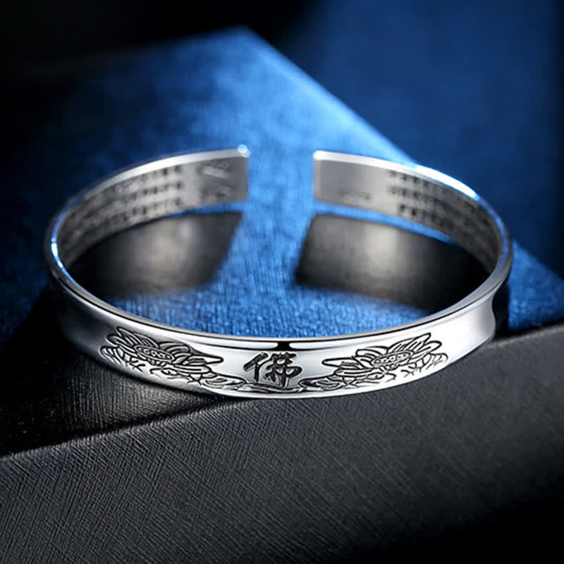 Silbernes Armband mit Herzsutra-Gravur auf blauem Stoff elegant.
