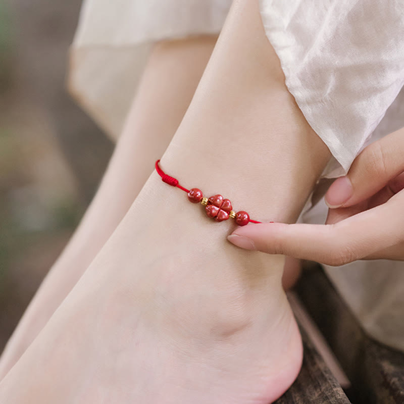 Rotes Armband Zinnober Kleeblatt am Handgelenk getragen, Liebe und Segen
