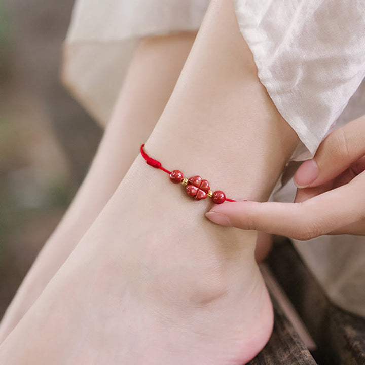 Rotes Armband Zinnober Kleeblatt am Handgelenk getragen, Liebe und Segen