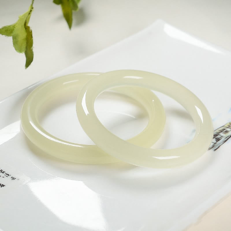 Armband Jade – Fülle hellgrüne Ringe auf weißem Teller Naturstein