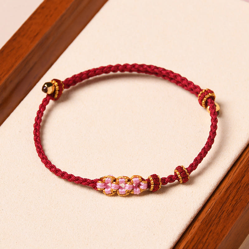 Rotes Armband Pfirsichblüte – Schutz mit goldenen Perlen elastisch.