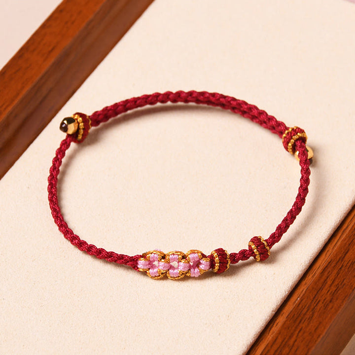 Rotes Armband Pfirsichblüte – Schutz mit goldenen Perlen elastisch.