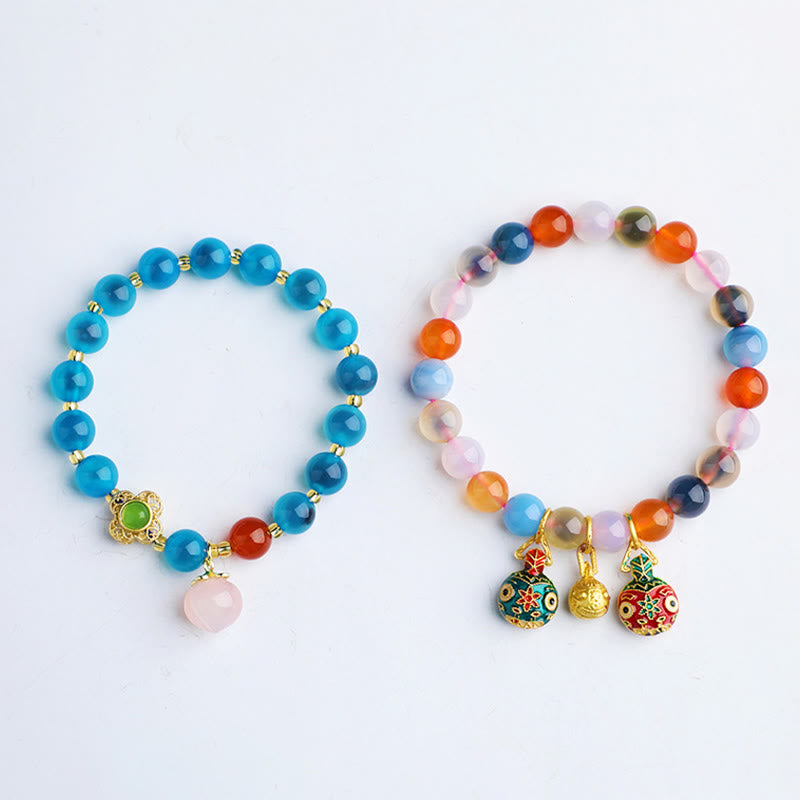 Zwei bunte Achat Armbänder mit goldfarbenen Perlen und Anhängern.