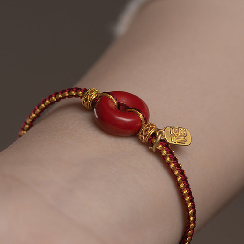 Rotes Zinnober Armband mit Fu-Zeichen Segen Symbol elegant getragen