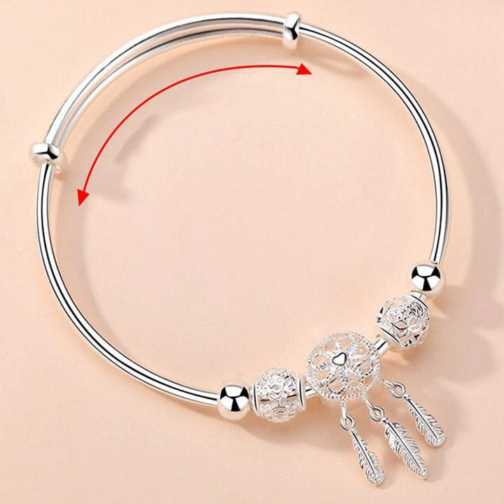 Silbernes Armband mit Perlen und Federn Anhängern elegant.