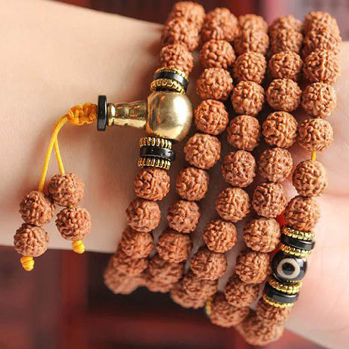 Mala Bodhi Armband mit braunen Rudraksha-Perlen und goldenen Metallakzenten getragen