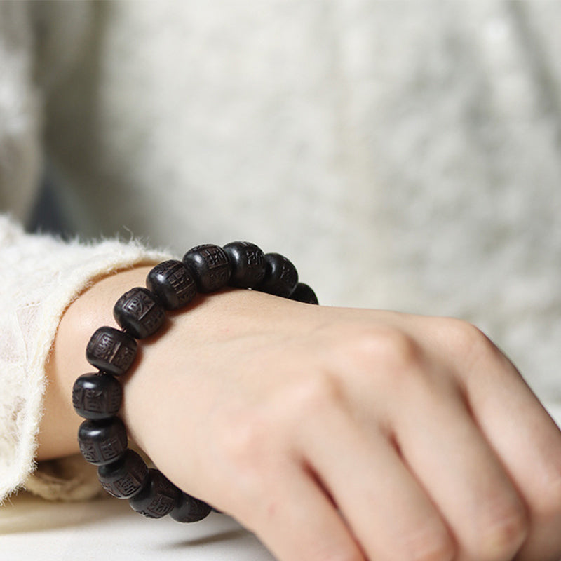 Schwarzes Ebenholz Armband mit Om-Symbolen am Handgelenk getragen