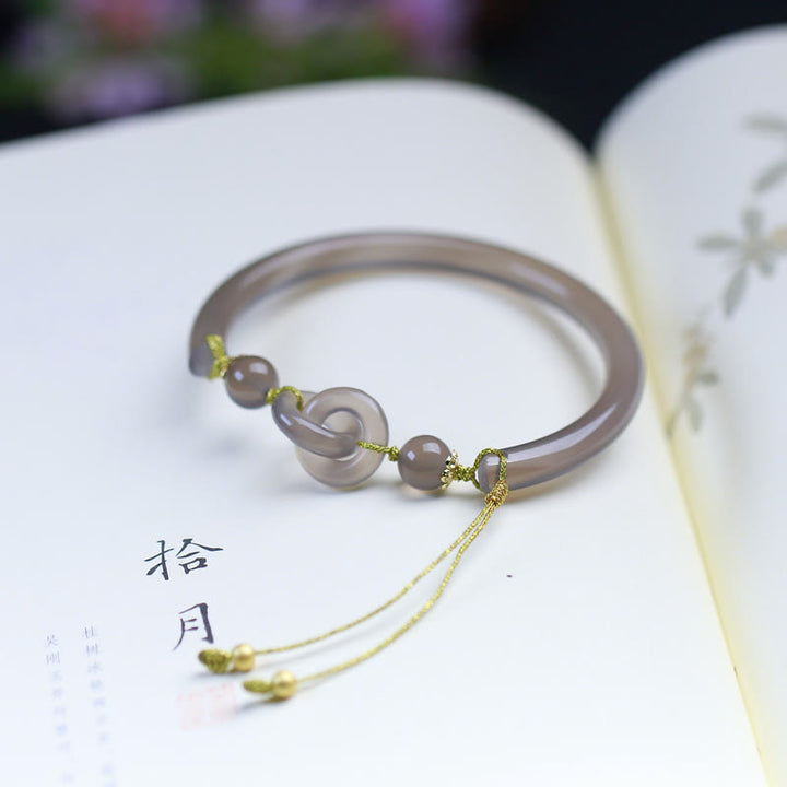 Achat Armband mit goldenen Perlen auf offenem Buch elegantes Design.