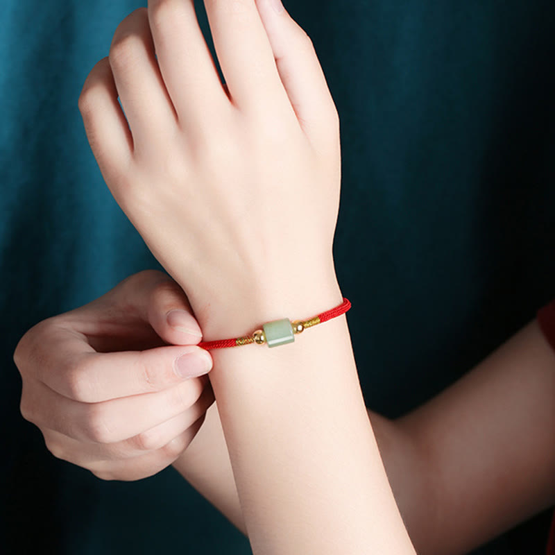 Rotes Seidenarmband mit grünem Aventurin Stein elegant am Handgelenk.