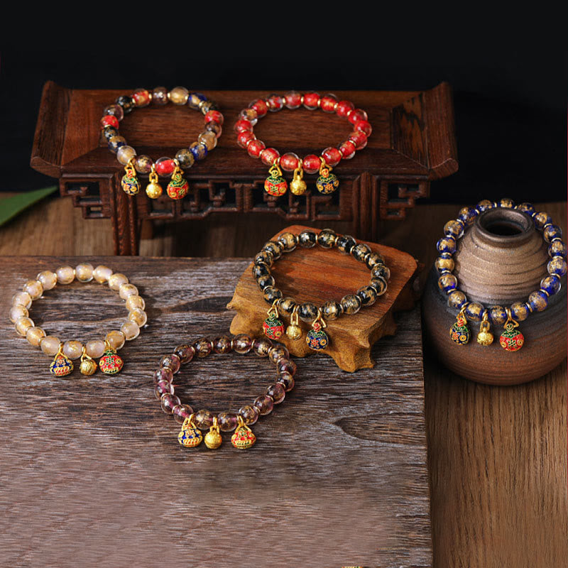 Bunte Perlen Armbänder mit goldenen Anhängern Holz Hintergrund