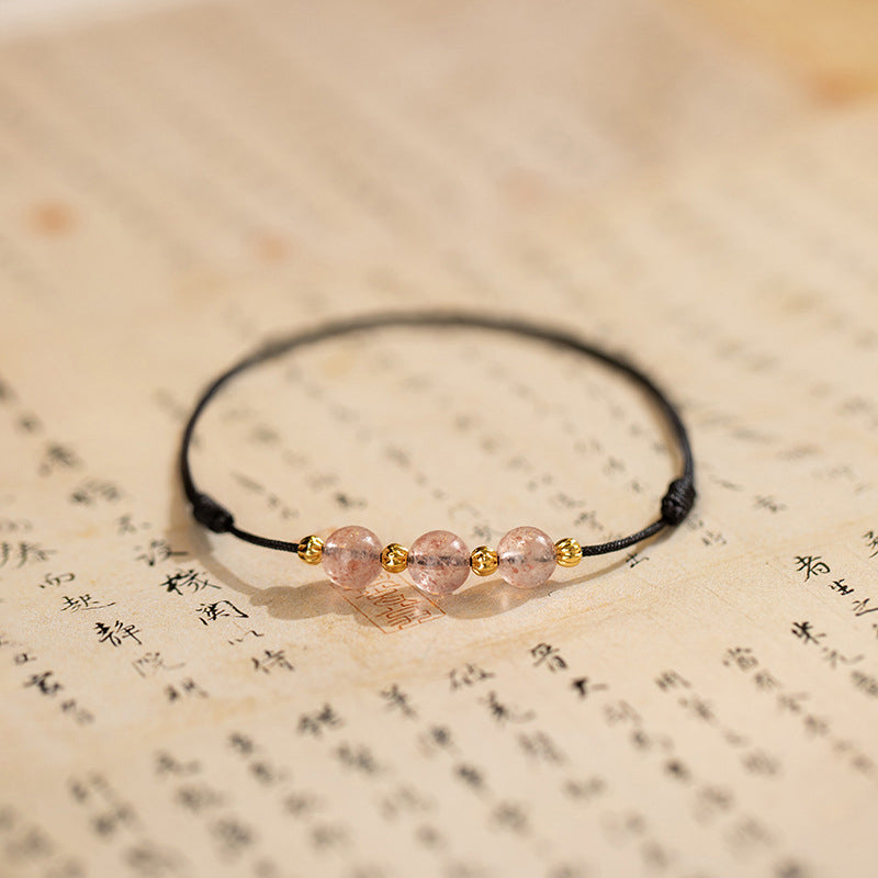 Armband Erdbeerquarz mit rosa Steinen auf Textuntergrund Flatlays