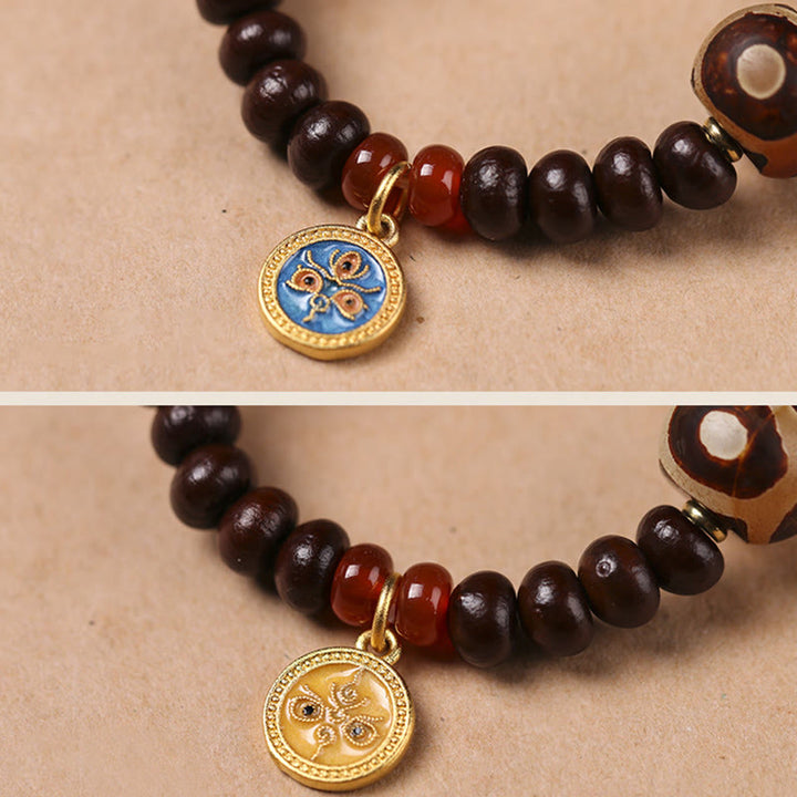Bodhi Armband mit dunkelbraunen Perlen und goldenem Anhänger Wohlstand.