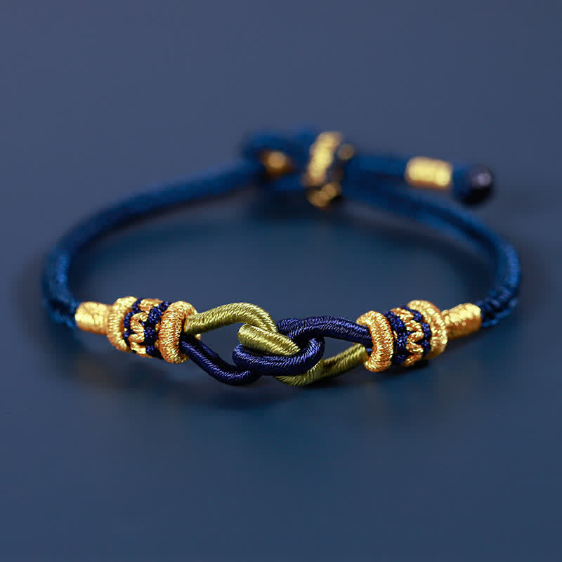 Blaues geflochtenes Armband mit goldenen Knoten Stärke Symbol.
