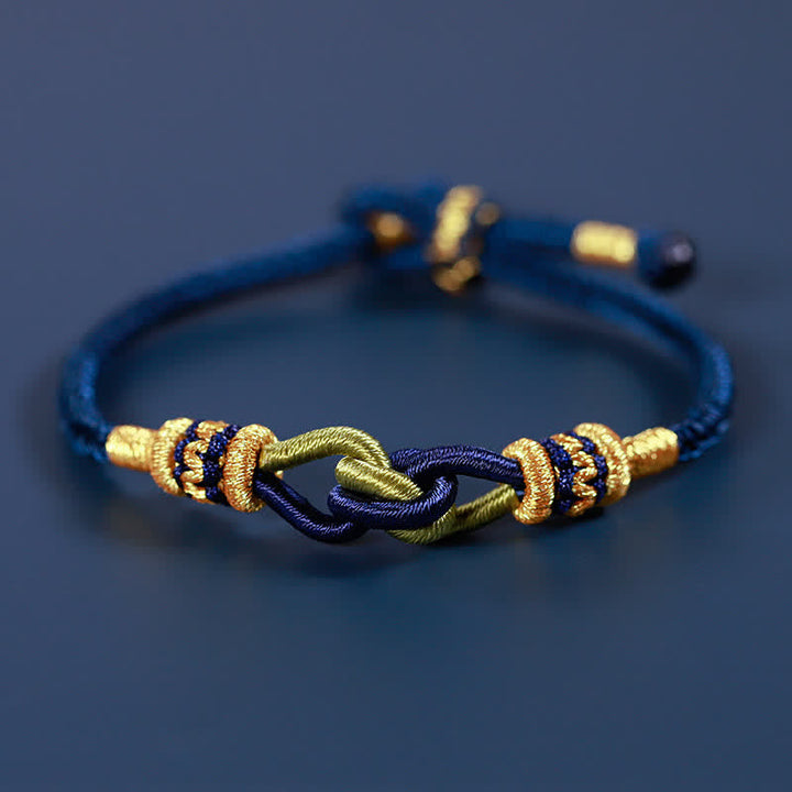 Blaues geflochtenes Armband mit goldenen Knoten Stärke Symbol.