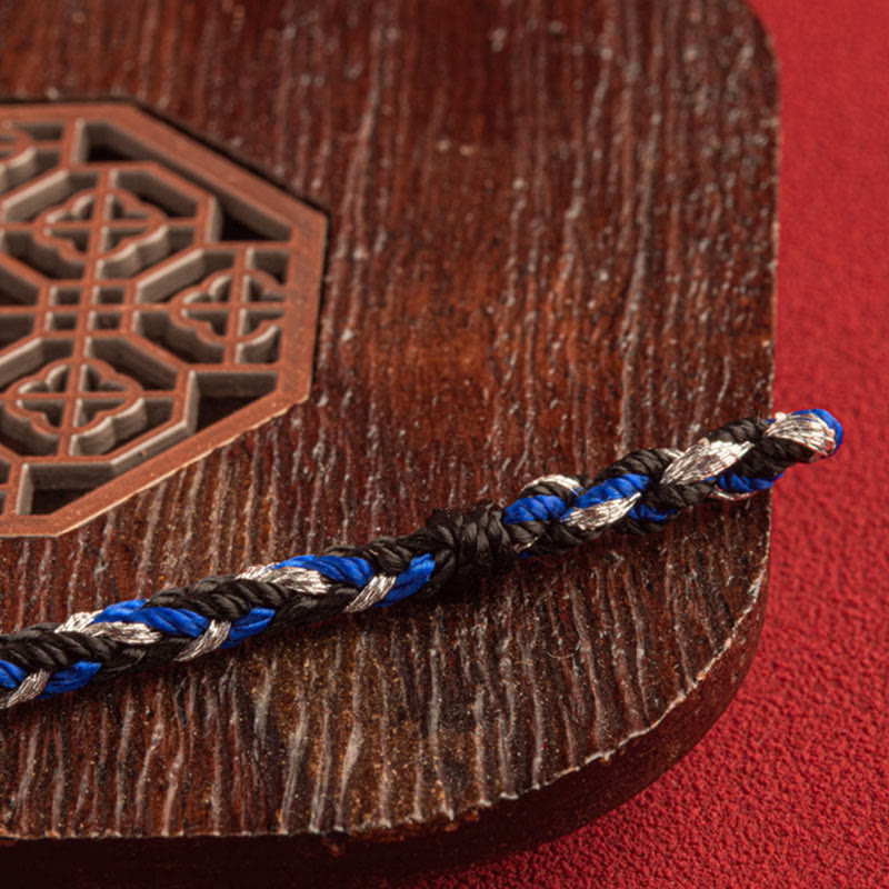 Armband Mehrfarbig Glücksband blau schwarz silber auf Holz Nahaufnahme