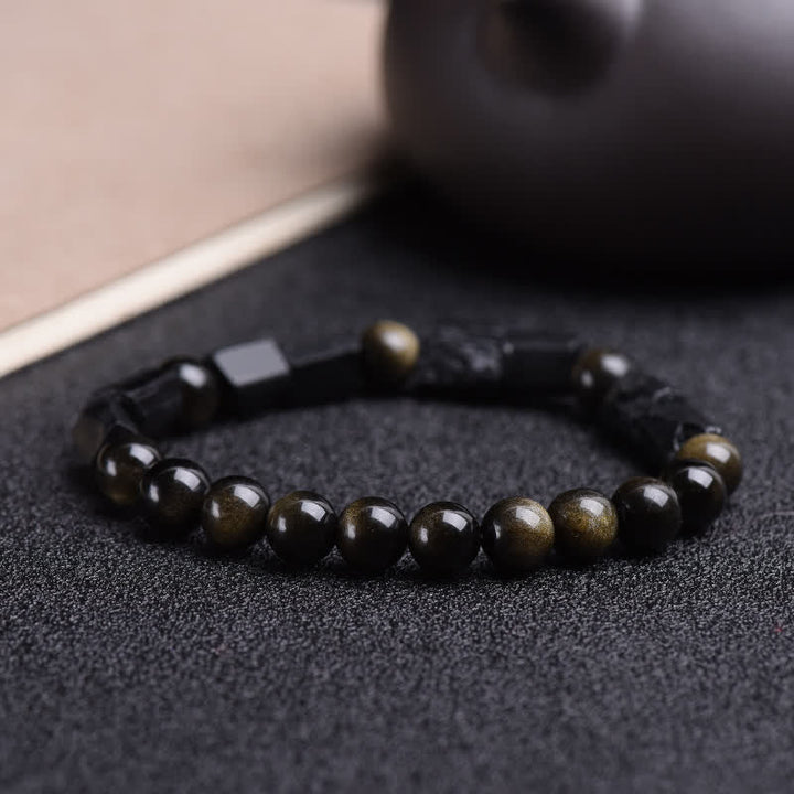 Obsidian Armband mit goldenen Flecken auf dunklem Untergrund, Nahaufnahme Schmuck