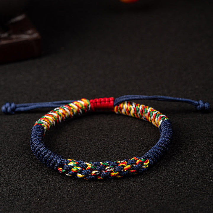 Bunte Mala Armband mit blauem Seil auf dunklem Hintergrund Nahaufnahme