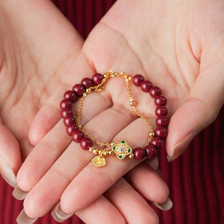 Rotes Zinnober Armband mit Kleeblatt Charm elegant am Handgelenk getragen